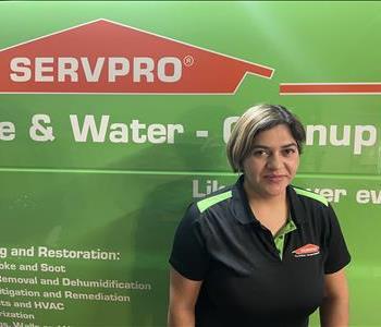 Image of female employee standing in front of a SERVPRO truck with a SERVPRO shirt