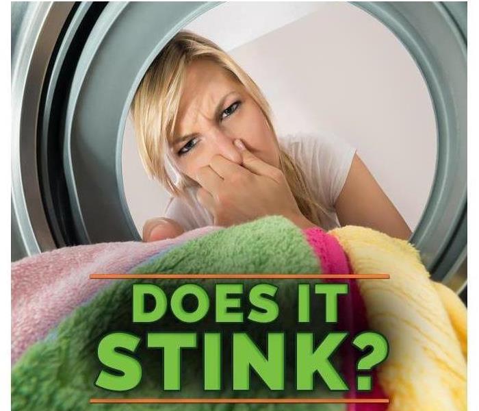 Image of a person plugging her nose when opening the washer, with green letters stating "does it stink?"